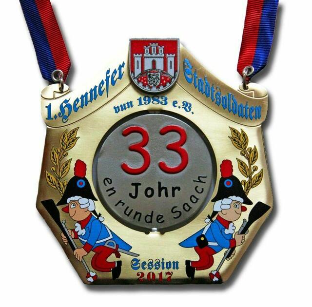1. Hennefer Stadtsoldaten - Den Mittelpunkt des diesjährigen Sessionsordens bildet ein Drehtaler, der auf der einen Seite das Motto preisgibt: „33 Johr (Stadtsoldaten) en runde Saach.“ Auf der Rückseite erkennt man das Kurhäuschen, das von einem Feuerwerk anlässlich unserer Feierlichkeiten zum „33 jährigen Bestehen“ überstrahlt wird. Im Vordergrund sind die Tänzer der befreundeten Karnevalsvereine zu sehen, die mit dazu beigetragen haben, dass insgesamt 228 Tänzer den Laridah aufgeführt haben. Eingerahmt wird der Taler von zwei wibbelnden Stadtsoldaten, die mittig die Session 2017 erkennen lassen. Eichenlaub bedeckt die Häupter, als Hinweis auf unsere Jubelsession. Den Abschluss nach oben bildet das Stadtwappen Hennefs und der Schriftzug "1. Hennefer Stadtsoldaten vun 1983 e.V." | Foto: Repro Verlag