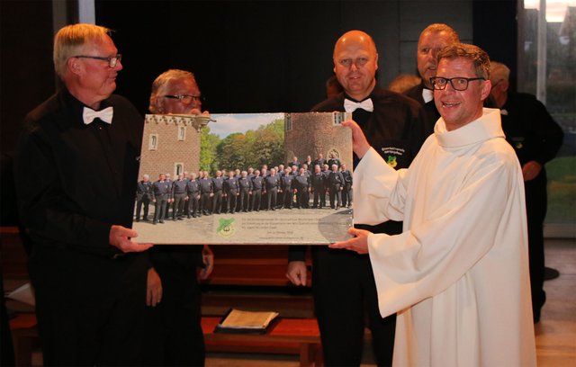 Pastor Noel-Hendrik Klentze (rechts) freute sich über das Chorfoto des Quartettverein in Form einer Leinwand mit Widmung für die Kirchengemeinde St. Christophorus. | Foto: Bastian Schlößer