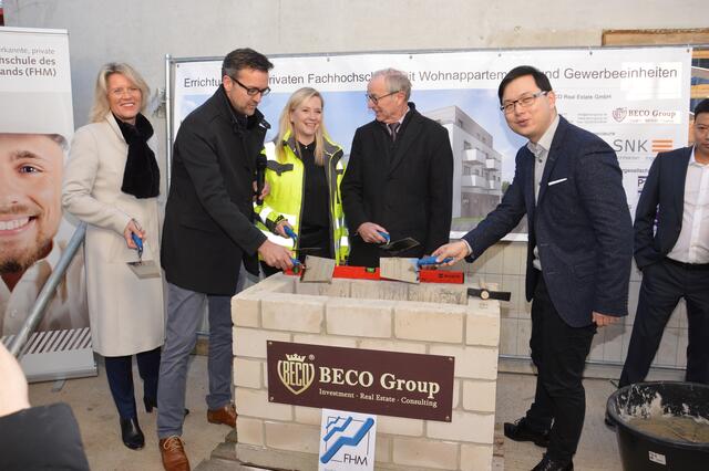 Im Beisein von Bürgermeisterin Susanne Stupp (Mitte), der FHM-Rektorin Professor Dr. Anne Dreier und dem stellvertretenden Landrat Bernhard Ripp (2.v.re.) mauerten Beco-Geschäftsführer Hongwei Xiong (re.) und Architekt Raoul Kramer unter anderem chinesische Münzen in den Grundstein des Campus-Gebäudes. | Foto: Lars Kindermann