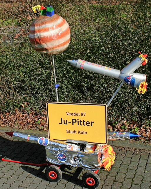Kennziffer 26 - Der Karnevalsverein Schnieke-Funke 08/15 e.V. zeigt den neuen Kölner Stadtteil „Ju-Pitter", dass Veedel 87. In orangefarbenem Astronautenanzug mit Warp-Antrieb auf dem Rücken und dem Dom im Gepäck gründen sie in Lichtgeschwindigkeit ein neues Veedel im All. Als kölsche Astronauten (KASA) auf Apollonia-Mission besiedeln sie den Ju-Pitter.  | Foto: Schnieke Funke