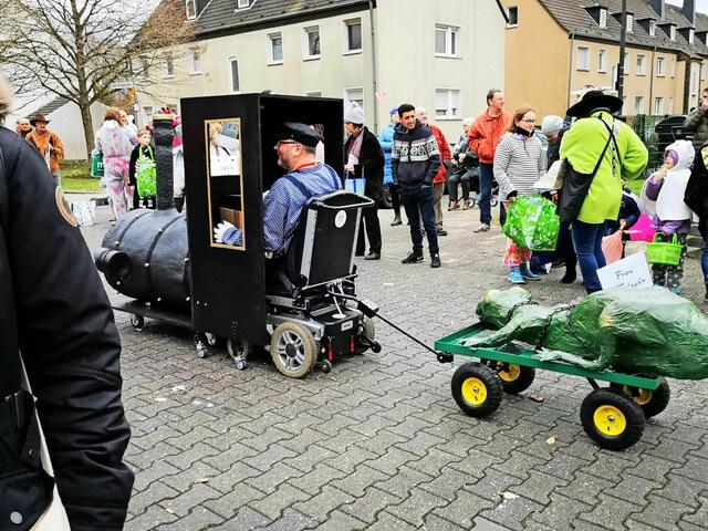 Kennziffer 51 - Paul Ittenbach (50) aus Troisdorf hat, im Teamwork mit seiner Frau Julia Dotzel und seinem Freund Olaf König, seinen elektrischen Rollstuhl in einen Karnevalswagen umfunktioniert. An der Lok Emma aus Michael Endes „Jim Knopf und Lukas der Lokomotivführer“ hängt die gefangene Frau Mahlzahn. | Foto: Paul Ittenbach