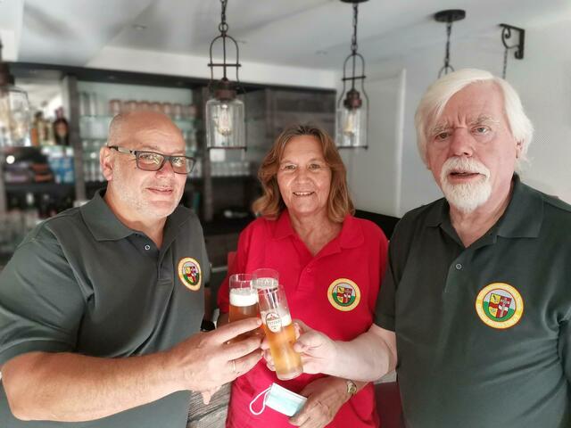 Ein Prosit auf die lang ersehnte Eröffnung vom geschäftsführenden Vorstand des "Em Dörp" e.V.: Anita Bäumerich, Walter Cremer (r.) und Meinhard Tappert. | Foto: Volker Düster