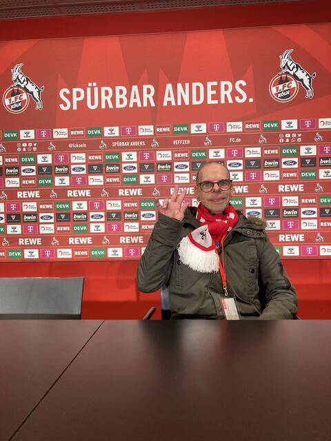Hier ist Ralf Faßbender im Pressebereich und sitzt auf dem Stuhl, auf dem später Steffen Baumgart sitzt bei der Presse-Konferenz. Der 1. FC Köln ist Spürbar anders und setzt sich unter dem #andersGLEICH für Inklusion und Teilhabe ein.  | Foto: Blatt-Gold