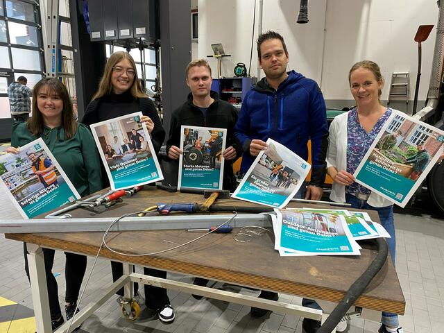 Sie stellten die Plakatkampagne vor (v.l.) Lisa Marleen Forrell (Azubi-Verantwortliche FB 1), Michelle Krah (Auszubildende), Maik Scharf (Mechatroniker in der Kfz-Werkstatt), Marco Braun (Leiter der Kfz-Werkstatt) und Stefanie Köllen (Projektverantwortliche für die Arbeitgebermarke im FB 1). Foto: Stadt BGL