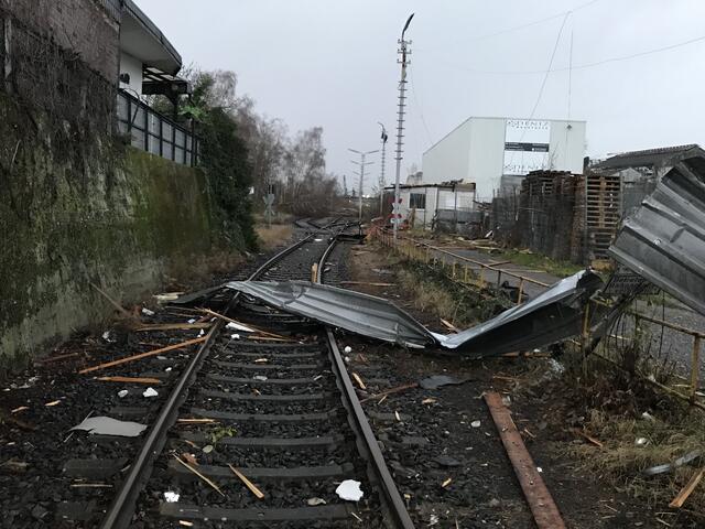 Kaputte Wellblechdächer und ungefallene Bäume liegen auf den Gleisen.  | Foto: Büge