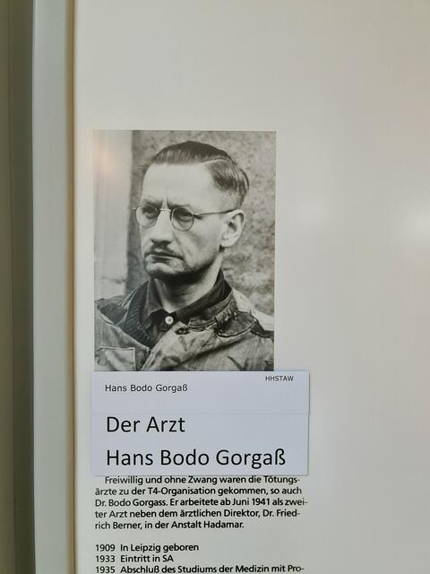 Im Keller ist ein kleiner Raum wo ein Arzt der vorher die Leute untersucht hatte und sogar markiert hatte in diesem Raum gesessen hat und durch ein Guck-Loch kucken konnte und dann den Gas Hebel betätigt hat. Der Arzt hieß Hans Bodo Gorgaß. Er trägt eine Nickelbrille. Seine Haare sind an den Seiten kurz und streng zurückgegelt und ein ernster Blick. Er sieht grimmig aus und unfreundlich, so als würde ihn das Ganze kalt lassen. Er hat das freiwillig gemacht.  | Foto: Blatt-Gold