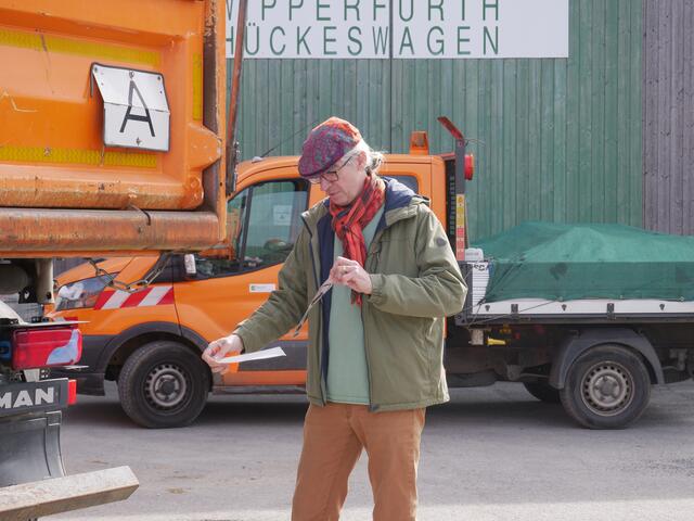 Alfons Herweg bringt den Aufkleber an einem Fahrzeug des Bauhofes an.