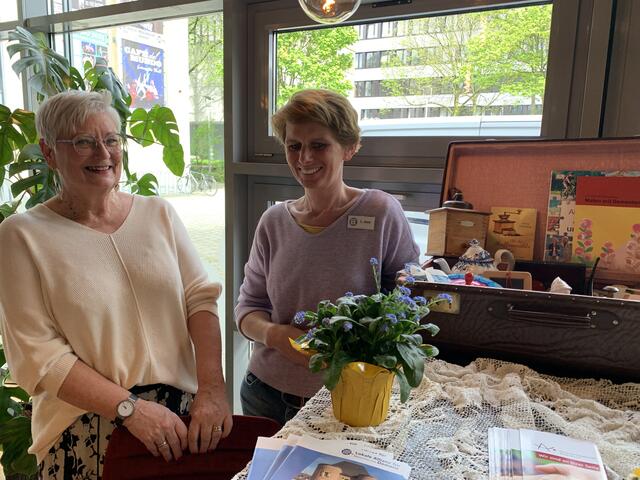 Moderatorin Christa Wolf und Lisa Joos von der Stadtbibliothek Bergheim präsentieren den "Erinnerungskoffer", den es auch zur Ausleihe gibt.  | Foto: Andrea Floß