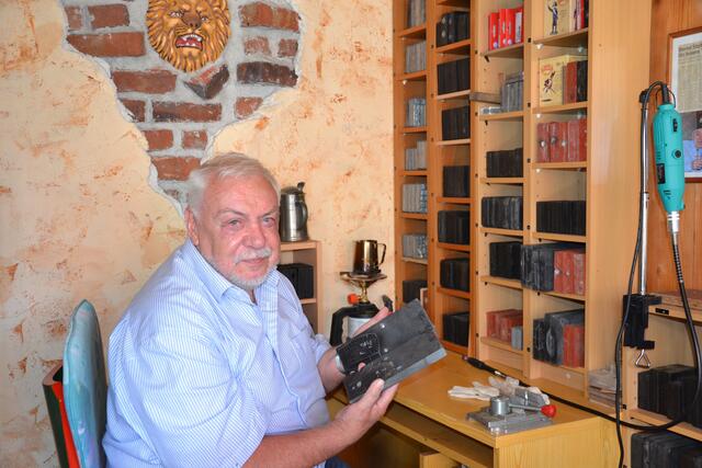 Franz Josef Gronewald in seiner kleinen Werkstatt mit einer Gießschablone aus Schieferstein. Die fertigen Gießformen bewahrt er, fein säuberlich sortiert, in einem Regal auf. | Foto: Lars Kindermann