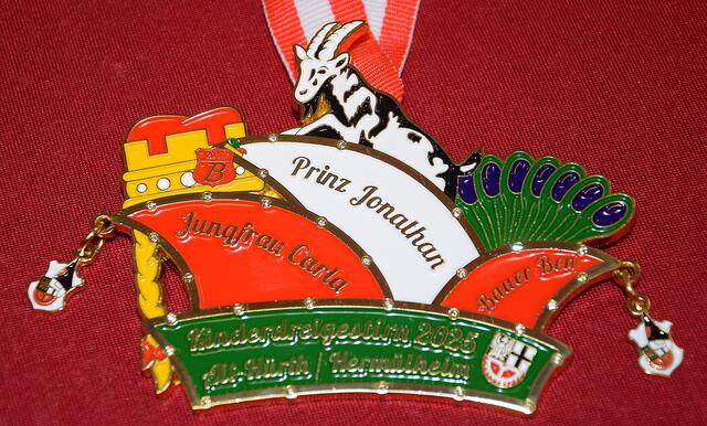 Kinder3gestirn Alt-Hürth und Hermülheim
Der farbenfrohe Tollitätenorden ist geformt aus drei typischen Kopfbedeckungen eines Dreigestirns. Der kölsche Hennes wacht über die eingefleischten FC-Fans. | Foto: Martina Thiele-Effertz