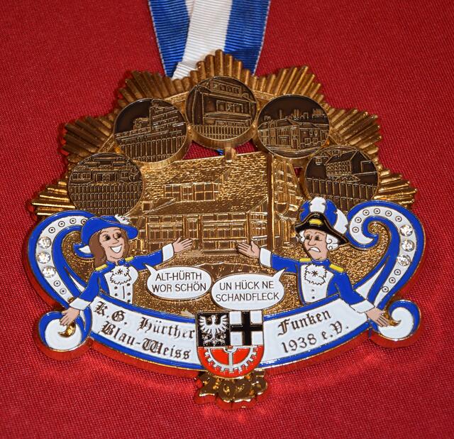 KG Hürther Funken Blau-Weiss 1938 e.V.
Wie ein Mottowagen im Rosenmontagszug beschreibt der Orden kritisch die Entwicklung in Alt-Hürth am Beispiel früherer Highlights wie Paula und dem alten Schwimmbad. | Foto: Martina Thiele-Effertz