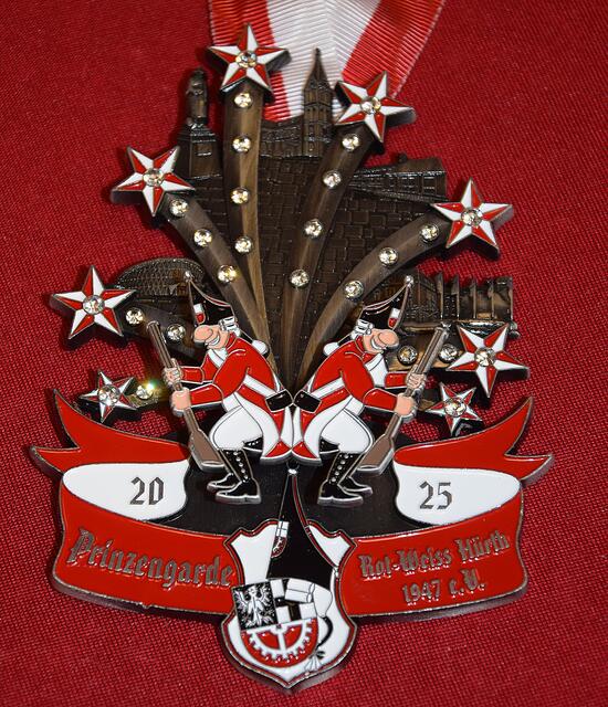 Unser Orden steht in dieser Session unter dem Motto "Wenn am Himmel de Stääne danze...Das Lied, welches die Klüngelköpp herausgebracht haben passt auf unseren Orden, wie die Faust aufs Auge. "Un von unserer Kirch de Glocke klinge..." Deshalb ist unsere Kirche St. Katharina in unserem Orden mitaufgeführt. In unserem Ort feiert in diesem Jahr die Clementinenschule Jubiläum und hat es somit auch auf unseren Orden geschafft.! Als Dankeschön für die letzte Session, wo die Prinzengarde Rot-Weiss Hürth selbst das Dreigestirn stellen durfte, darf das H+ Hotel als Hofburg des Dreigestirns natürlich nicht fehlen. Weitere Gebäude prägen den Orden und stehen in enger Verbindung mit unserem Verein. Die beweglichen Gardisten, die schwingend die Stippefott präsentieren, sind eins der besonderen Highlights des Ordens. | Foto: Martina Thiele-Effertz