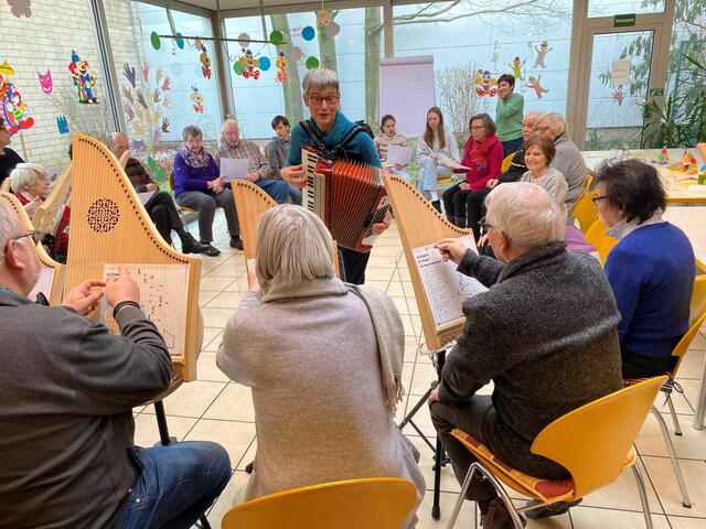 Bei der Vormittagsbetreuung der Gruppe "Füreinander" macht Ulla Henkel mit Seniorinnen und Senioren Musik.  | Foto: Andrea Floß