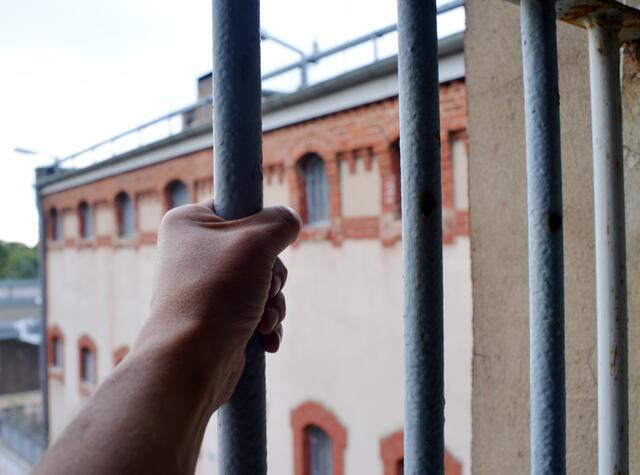Das Symbolfoto zeigt den Blick aus einer Gefängniszelle mit vergittertem Fenster. | Foto: Sinuswelle - stock.adobe.com