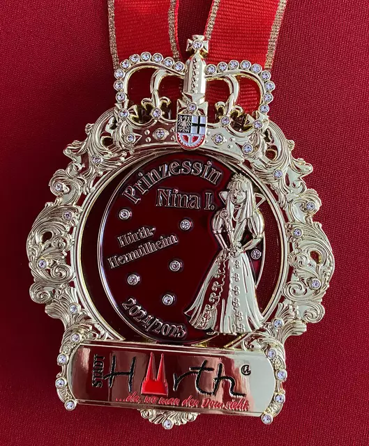 Der Orden von Prinzessin Nina I. aus Hermülheim zeigt im Zentrum des gekrönten Ordens das Abbild der Prinzessin selbst in den Farben ihres Ornats. Der Bezug zur Stadt Hürth ist durch das Wappen der Stadt und das Logo aus der Hürth-Kollektion ersichtlich. Es erinnert an einen Aprilscherz der Hürther, die sich einen Spaß daraus gemacht hatten, den Dom, ins Logo von Hürth zu integrieren. Der Spruch dabei: „Da, wo man den Dom sieht“. | Foto: Tiefenthal