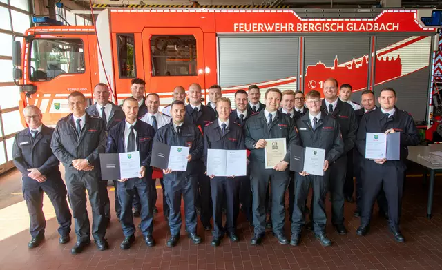 18 neue Brandmeister (v.l.): Marc Pöschel (Brandamtmann und Lehrgangsleiter der Kölner Feuerwehr), Christian Müller (Lehrgangsleiter Bergisch Gladbacher Feuerwehr) und Marten Sperber (Brandamtsrat und Schulleiter der Feuerwehr Bergisch Gladbach) mit den erfolgreichen Lehrgangs-Absolventen Foto: Axel König