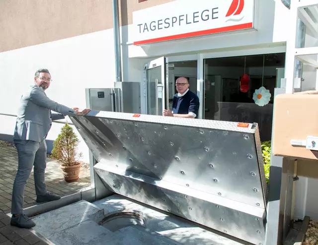 Geschäftsführer Michael Heine (v.l.) demonstriert das Schließen eines der Schotts. Martin Schneider, Pflegefachkraft im Stift, sowie alle weiteren Menschen im Haus „Tagespflege“ wären dann vor Hochwasser geschützt. Foto: Axel König