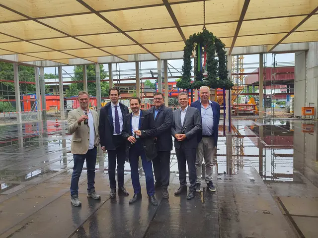 Bürgermeister Matthias Großgarten (3.v.l.) und Bauunternehmer Hans-Josef Klein aus Rheidt (rechts) stoßen mit den Verantwortlichen der Firma Bauwens aufs Richtfest an.  | Foto: Bracker