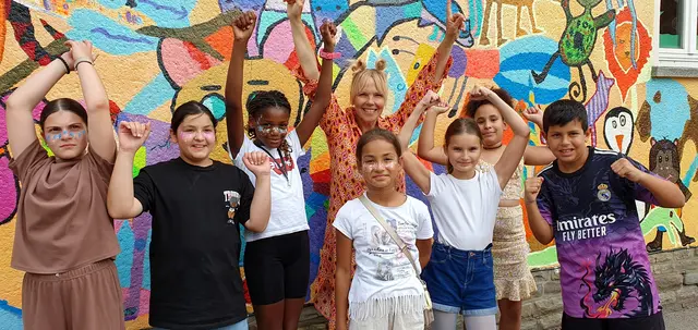 Künstlerin Britta Reinhardt und Kinder des vierten Schuljahres schufen auf dem Schulhof der Quettinger Grundschule ein farbenfrohes Gemeinschaftswerk. Foto: Gabi Knops-Feiler 