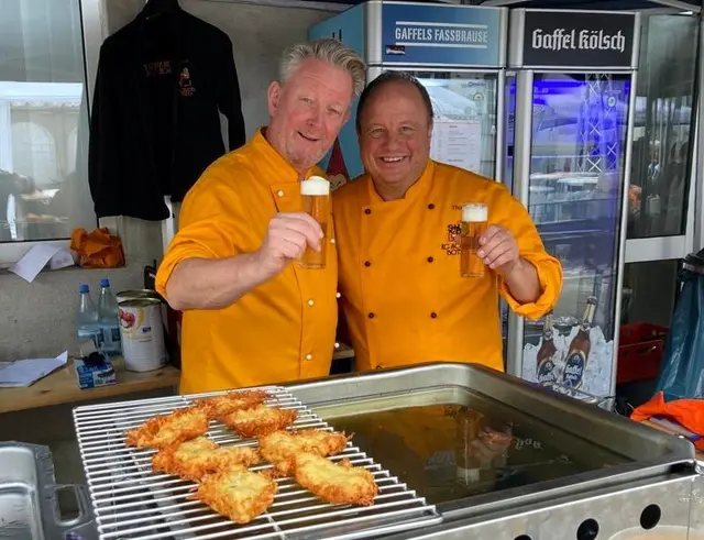 Hardy Zolper (l.)  und Thomas Hiesserich, beides aktive Mitglieder der Schlader Botze, am Reibekuchenstand. Foto: Schlader Botze