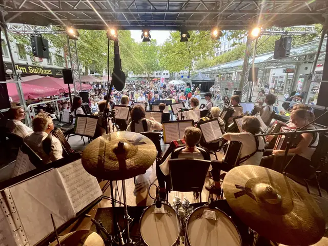 Ein Blick vom Schlagzeug auf der Bühne auf das Workshop-Orchester "Gemeinsam musizieren mit Quetsch" und den Friedensplatz.  | Foto: Olek Gelba