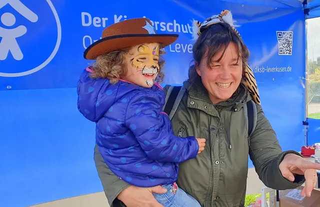 Löwenstark unterwegs: Minell, die kleine Raubkatze, genießt auf dem Arm von Mama Evelyn den fröhlichen Tag beim Kinderfest im Neulandpark. Foto: Gabi Knops-Feiler