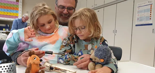 Opa Uwe bastelte gemeinsam mit Elina (l.) und ihrem Bruder Jonathan eine Taschenlampe, während die Plüsch-Maus und die Igel-Handpuppe „Luna“ zusahen. Foto: Gabi Knops-Feiler