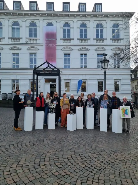 Sie präsentieren das Booklet „Kunst Hand Werk Siegburg“ (von links): Petra Göldner, Markus Weisheit, Miriam Rousseau, Carina Molitor, Ines Rother, Nadine Weißenfels, Karin Dornbusch, Elpida Gerasimidou, Katja Zander, Delia Sedlmeier, Charly Halft, Kerstin am Ende, Bürgermeister Stefan Rosemann, Hans-Willi Kernenbach und Annette Preiß.
 | Foto: Kreisstadt Siegburg