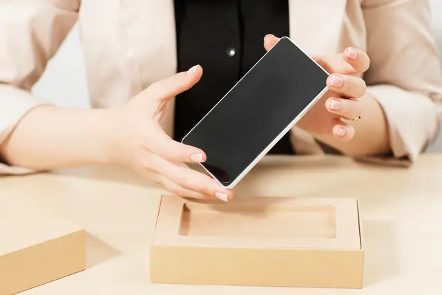 Ein Smartphone wird aus der Verpackung genommen. Symbolfoto. | Foto: golubovy - stock.adobe.com
