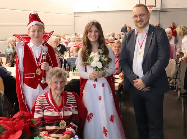 Die 99-jährige Else Henkel sitzt fit in der Runde und erfreut sich am Karnevalsorden des Hänscheider Kinderprinzenpaares. | Foto: Steimel