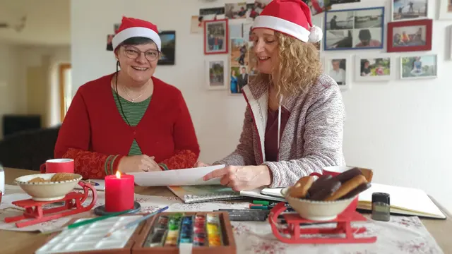 Bei der ersten Besprechung – symbolisch begleitet von Aachener Printen und weihnachtlichem Outfit – einigten sich Kathrin Bräker (l.) und Myria Stricker auf ein Motiv, das beide Welten von „Wilmas Weihnachten – Karlas Weihnachten“ verbindet. Dabei wurde deutlich: Die Gestaltung ist eine kleine Herausforderung, denn Titel, Umschlag und Illustrationen müssen von beiden Seiten funktionieren. Foto: Gabi Knops-Feiler