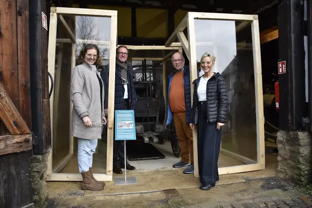 Die neue Schutzvitrine der Lokomobile in der Scheune des Bergischen Museums (v.l.): Sandra Brauer, Museumsleitung, Dr. Michael Metten, Geschäftsführer von Metten Stein+Design, Wihelm Carl, Vorsitzender des Museums-Fördervereins und Felicitas Eßer, Vorstandsmitglied der Bensberger Bürgerstiftung. Foto: Bergisches Museum/ Foto: Bettina Vormstein