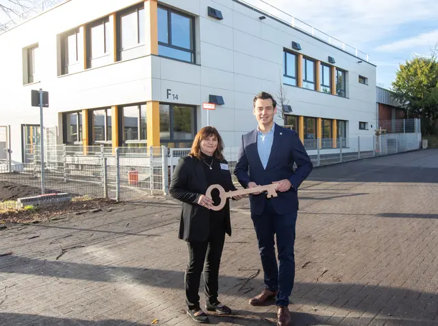 Vor dem Gebäude: Bürgermeister Marcel Kreutz überreichte Schulleiterin Sabine Hantel den symbolischen Schlüssel des Erweiterungsbaus. Foto: Axel König