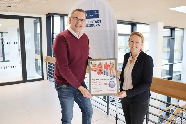  Verena Dienst überreicht Stefan Rosemann das Veranstaltungsplakat.  | Foto: Johanniter