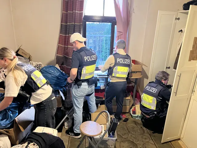 Beamten durchsuchen die Wohnung des Verdächtigen.  | Foto: Polizei Köln