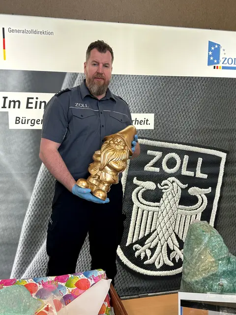Zoll-Pressesprecher Jens Ahland hält einen der zwei goldenen Zwerge in der Hand, in denen Drogen versteckt wurden. | Foto: Zoll Köln
