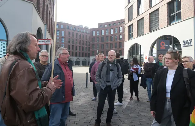 An der „Piazza“ der Ovum-Bürogebäude: Roland Schüler (l.) brachte den Teilnehmern auf einem Rundgang die Komplexität der Weststadt näher.   | Foto: Hans-Willi Hermans