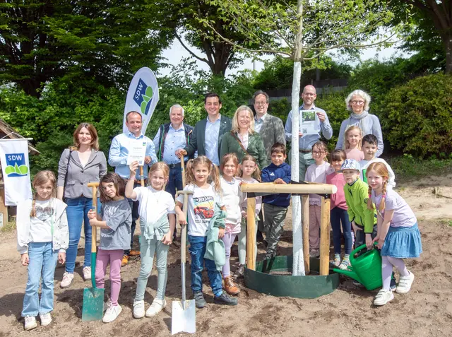 Der Tag des Baumes wurde in Evangelischen Grundschule Bensberg begangen (v.l.): Kinder der Grundschule mit (v.l.) Tülay Durdu und Martin Lucke (beide Landtagsabgeordnete), SDW-Rhein-Berg-Vorsitzender Rainer Deppe, Bürgermeister Marcel Kreutz, SDW-Landesvorsitzender Kerstin Radomski (ebenfalls Mitglied des Bundestages), Peter Lautz (stellvertretender Landrat), Master of Engineering und Landschaftsgärtner Christian Nollen (Stadtgrün-Abteilungsleiter) und Schulrektorin Kerstin Bacher. Foto: Axel König