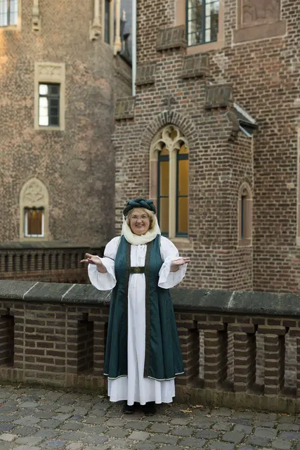 Zofe Brunhilde alias Gästeführerin Astrid Machuj empfängt ihre Gäste zu einer besonderen Erlebnisführung am Eingangstor des Schlosses Paffendorf. | Foto: Görgen
