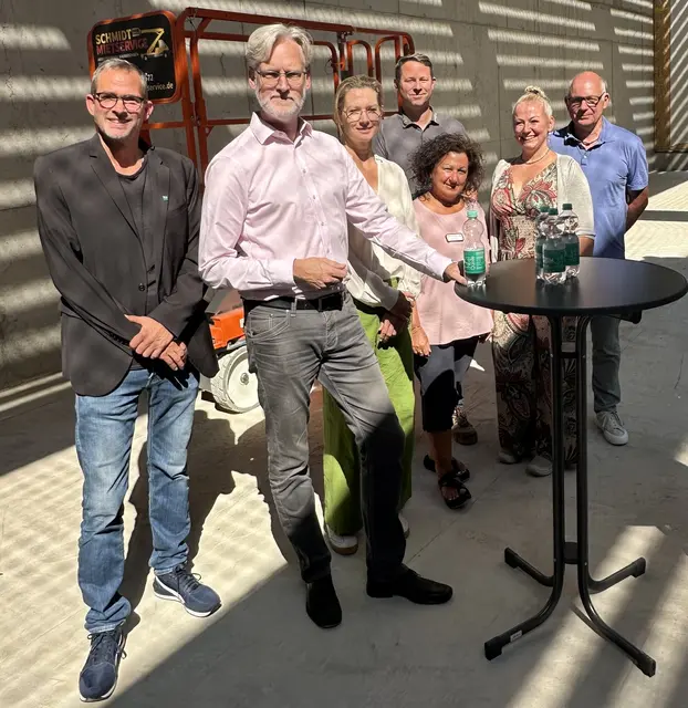 (v.l.): Jens Volkmer (Amtsleitung Jugend, Bildung, Sport), Erster Beigeordneter Thorsten Steinwartz, Architektin Miriam Jaeger (3ZW Architekten), Tota Kranzhoff (Leitung OGGS Overath), Schulleiterin Sylvia Grosser und Manfred Allmayer (Amtsleitung Immobilienmanagement). (2. Reihe hinten) Florian Hamacher (Geschäftsführer Hamacher Holzbau). Foto: S. Fielstette, Stadt Overath