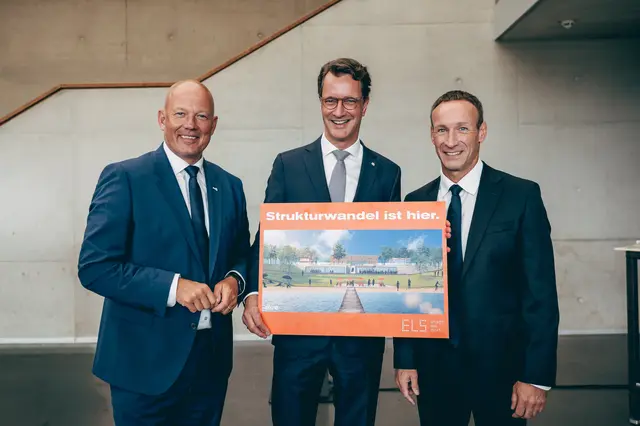 Bürgermeister Andreas Heller (r) - hier mit Landrat Frank Rock (l.)  -  übergibt Ministerpräsident Hendrik Wüst eine Illustration vom geplanten „Welcome Center“. | Foto: Rhein-Erft-Kreis/Schweinsburg
