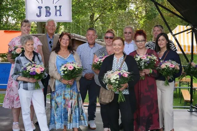 Ehrungen auf der Bühne (von links nach rechts): Claudia Neumann, stellvertretende Leitung „Kleine Strolche“, Inge Hüngsberg, stellvertretende Schatzmeisterin, Jörg-Peter Schlieder, Petra Opschondek, Leitung Fachberatung, Geschäftsführer Daniel Heinrich, Hanna Grunwald-Martin, Leitung Fachbereich Interdisziplinäre Eingliederungshilfe, Aleka Heinrich, Vorsitzende des Verwaltungsrats, Hans Hüngsberg, Yvonne Aziz, kommissarische Leitung Kinderburg, Nadine Roth, Leitung „Kleine Strolche“, Nina Heep-Mercurio – Leitung Kinderburg (z. Zt. in Elternzeit). | Foto: Jugendbehindertenhilfe Siegburg Rhein-Sieg