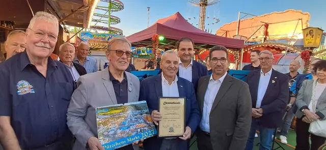 Urkundenübergabe an Albert Ritter durch den 1. Vorsitzenden Harald Borchert (mit Kalender) - Unmrahmt vom Vorstand des Freundeskreis sowie Oberbürgermeister Guido Déus, Minister Nathanael Liminski und Peter Barth, Vorsitzender des Schaustellerverband Bonn   | Foto: Freundeskreis Pützchens Markt e.V.