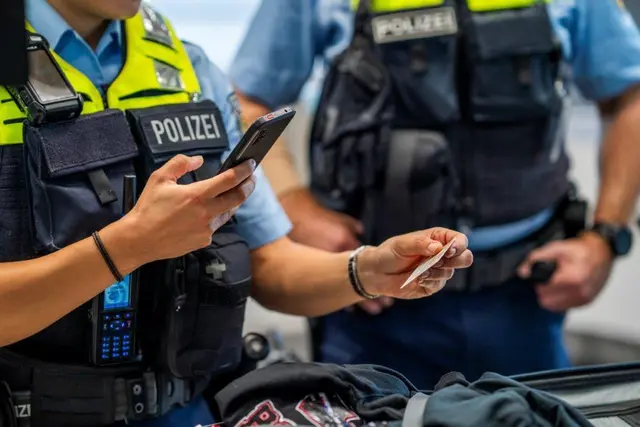 Zwei Beamte der Bundespolizei kontrollieren die Dokumente eines Reisenden. Symbolbild. | Foto: Bundespolizei