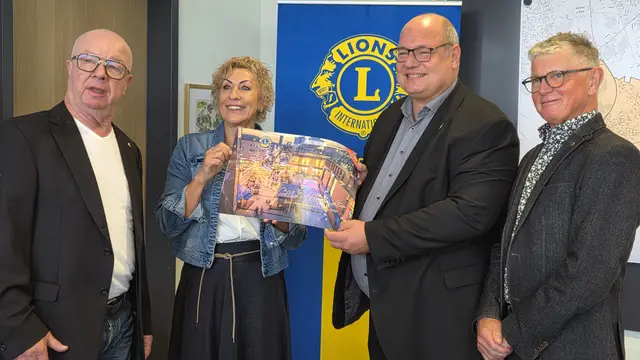 Oberbürgermeister Stefan Hebbel nimmt den Adventskalender mit der Nummer Eins von Friederike Hebbel entgegen. Uli Thoma (r.), Vize-Präsident des Lions-Clubs Rhein-Wupper und Dietmar Müller, Präsident von Rhenania, schauen dabei zu. Foto: Gabi Knops-Feiler 